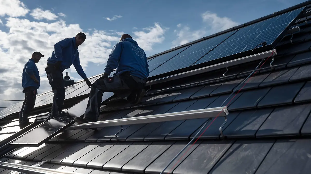 ARCHIV - 13.10.2021, Baden-Württemberg, Stuttgart: Mitarbeiter der Firma Sontec GmbH montieren Photovoltaikmodule auf dem Dach eines Wohnhauses. (zu dpa: «Solarpflicht in Baden-Württemberg bietet große Potenziale») Foto: Marijan Murat/dpa +++ dpa-Bildfunk +++