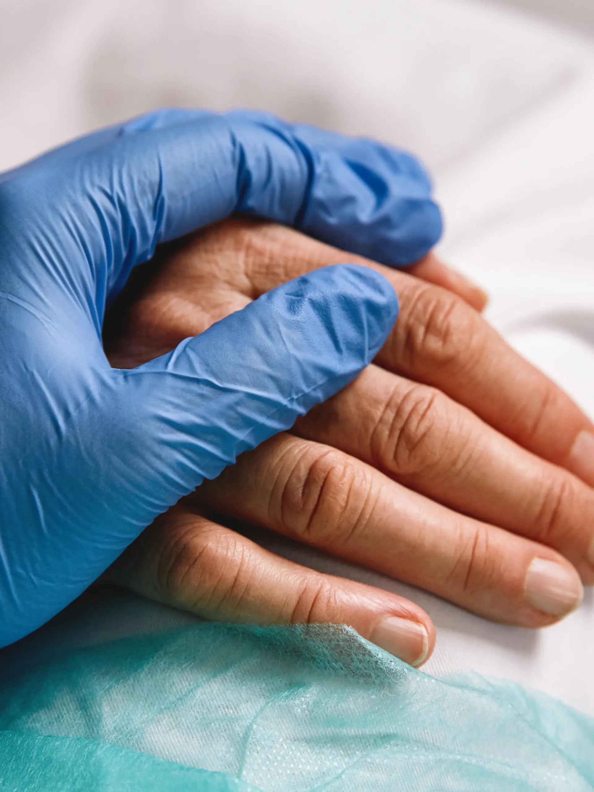 Pflegerin hält Hand einer Patientin