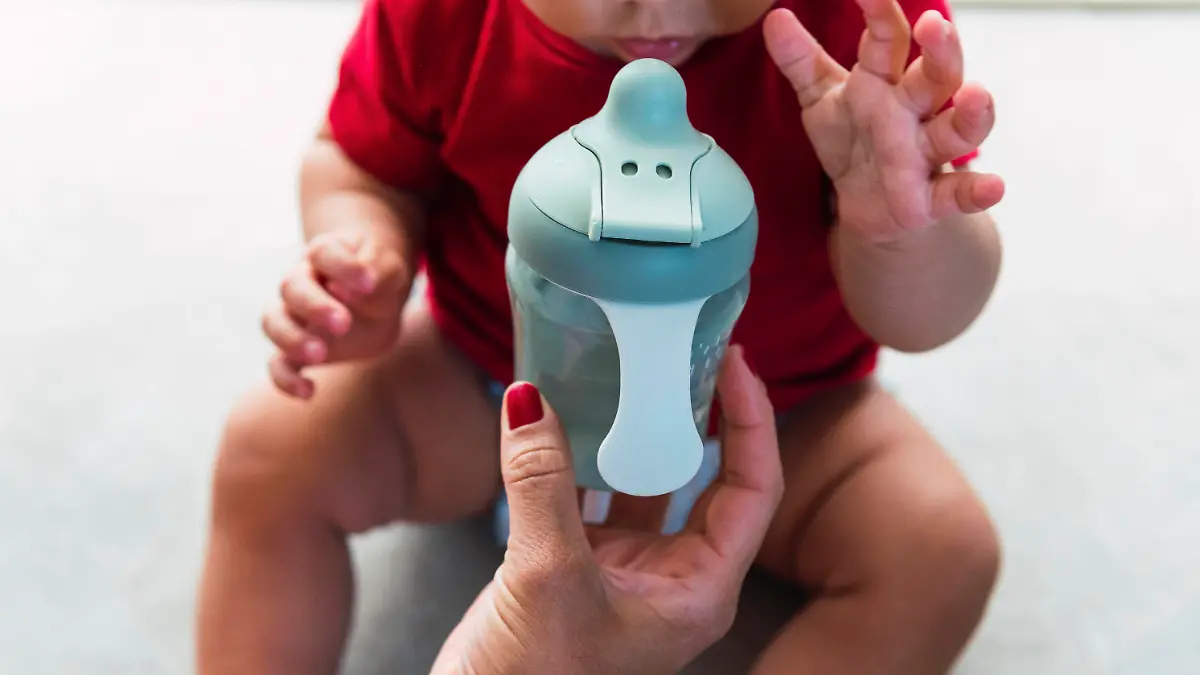 Mother giving baby bottle to son sitting at home model released, Symbolfoto property released, PNAF04524