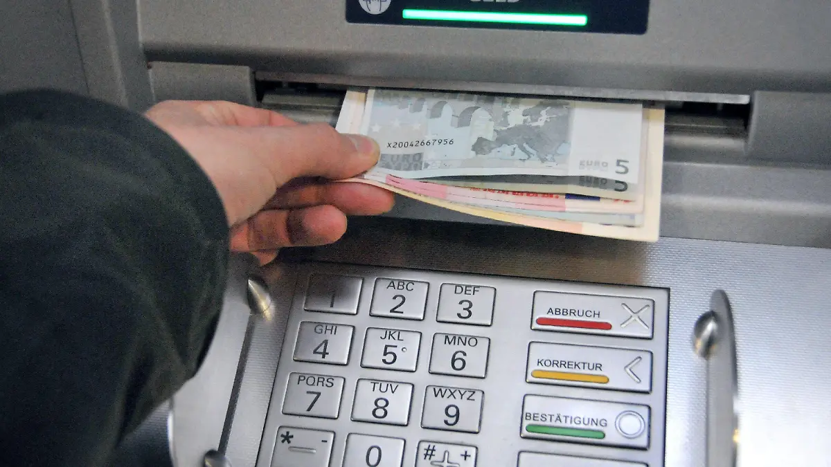 ARCHIV - Eine Hand entnimmt dem Geldschlitz eines Bankautomaten die gewünschten Banknoten (Archivfoto vom 07.11.2008). Geldautomaten in Deutschland werden immer häufiger manipuliert. Wie das Bundeskriminalamt (BKA) am Mittwoch (21.01.2009) in Wiesbaden berichtete, stieg die Zahl der Fälle im vergangenen Jahr stark an. Bundesweit hätten sich an 809 verschiedenen Geldautomaten Kriminelle zu schaffen gemacht, das entspricht einer Steigerung im Vergleich zum Vorjahr um 77 Prozent. Die Betrügereien verursachten einen Schaden von schätzungsweise mehr als 40 Millionen Euro. Foto: Uwe Zucchi (zu dpa 0460 vom 21.01.2009) +++(c) dpa - Bildfunk+++