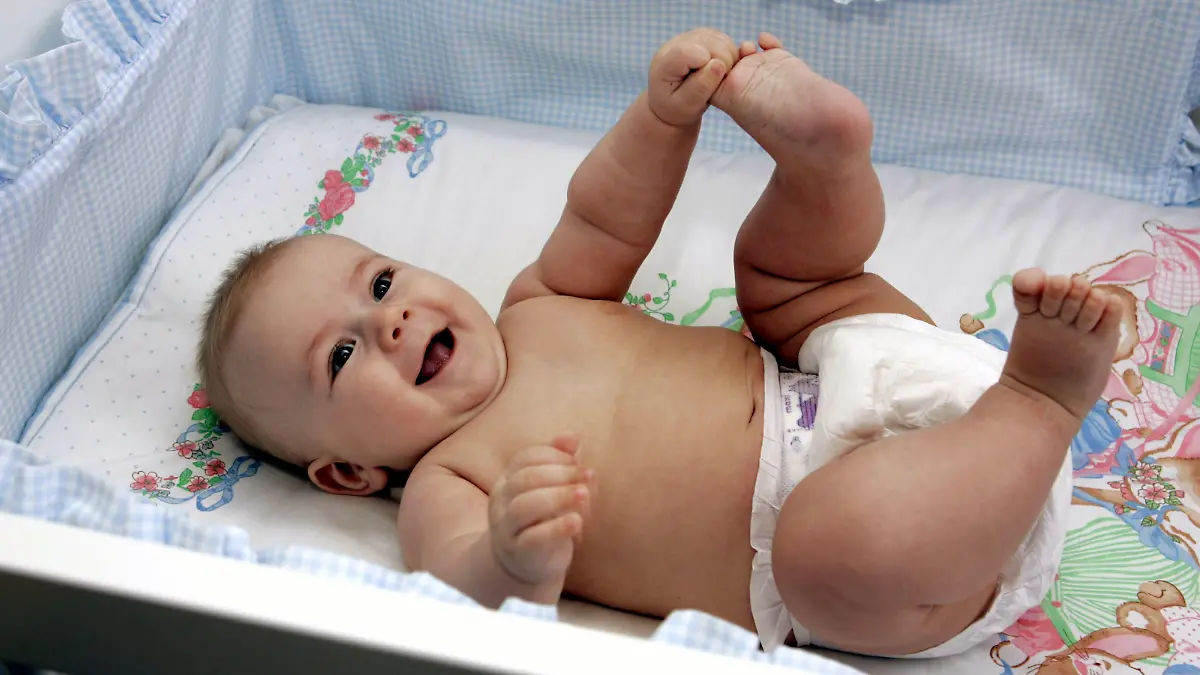 A baby boy in a diaper holds his toes lying in a baby bed, 11.04.2005. Foto: MARJA AIRIO / xMODEL RELEASED +++(c) dpa - Report+++