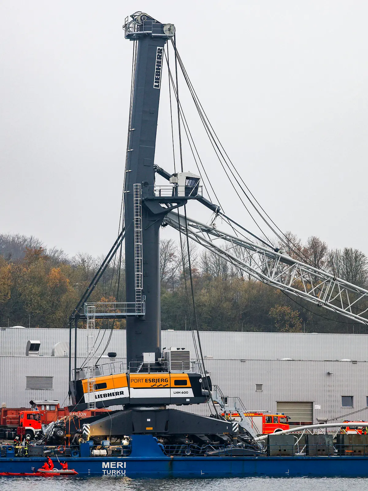 30.11.2022, Schleswig-Holstein, Kiel: Einsatzkräfte der Feuerwehr arbeiten an der ·Meri·, dem Schiff, das bei der Durchfahrt der Hochbrücke in Kiel-Holtenau mit der Brücke kollidiert war. Die Brücke wurde für den Schiffs- und Autoverkehr geperrt. Foto: Axel Heimken/dpa +++ dpa-Bildfunk +++