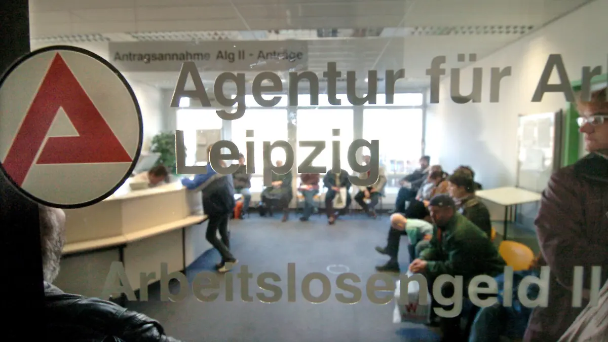 Hinter einer Glasscheibe einer Agentur für Arbeit in Leipzig herrscht am Dienstag (28.12.2004), dem offiziellen vorletzten Öffnungstag in diesem Jahr, noch großer Andrang bei der Antragsannahme für Arbeitslosengeld II. Im Bereich der Arbeitsagentur in Leipzig wurden in den letzten zwei Monaten rund 40.000 Bescheide an Antragsteller für ALG II herausgeschickt. Ab Januar 2005 erhalten in Deutschland Bezieher der bisherigen Arbeitslosenhilfe sowie arbeitsfähige Sozialhilfempfänger das neue Arbeitslosengeld II. Foto:Waltraud Grubitzsch/lsn +++(c) dpa - Bildfunk+++