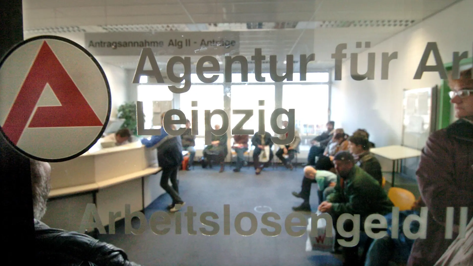 Hinter einer Glasscheibe einer Agentur für Arbeit in Leipzig herrscht am Dienstag (28.12.2004), dem offiziellen vorletzten Öffnungstag in diesem Jahr, noch großer Andrang bei der Antragsannahme für Arbeitslosengeld II. Im Bereich der Arbeitsagentur in Leipzig wurden in den letzten zwei Monaten rund 40.000 Bescheide an Antragsteller für ALG II herausgeschickt. Ab Januar 2005 erhalten in Deutschland Bezieher der bisherigen Arbeitslosenhilfe sowie arbeitsfähige Sozialhilfempfänger das neue Arbeitslosengeld II. Foto:Waltraud Grubitzsch/lsn +++(c) dpa - Bildfunk+++