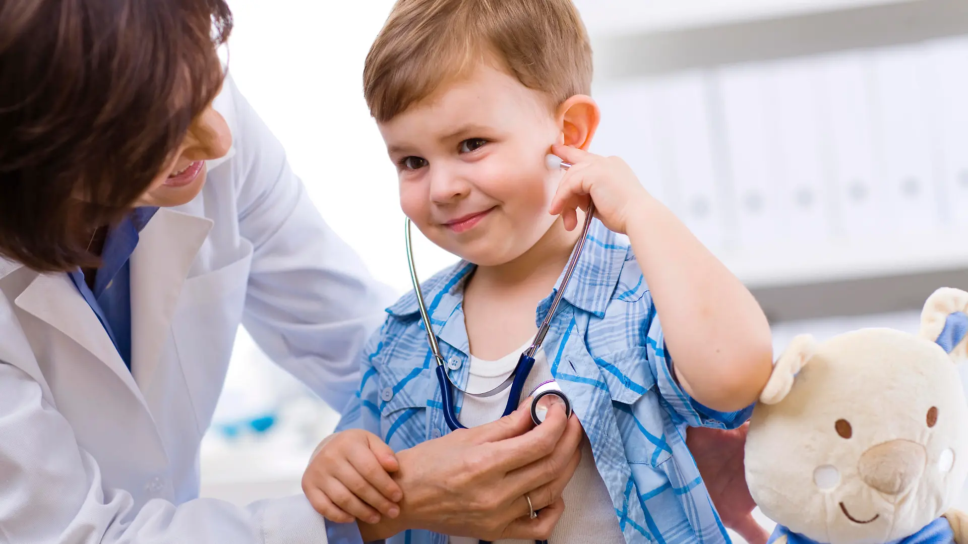 Senior female doctor examining happy child, smiling. Click here for more Medical photos
