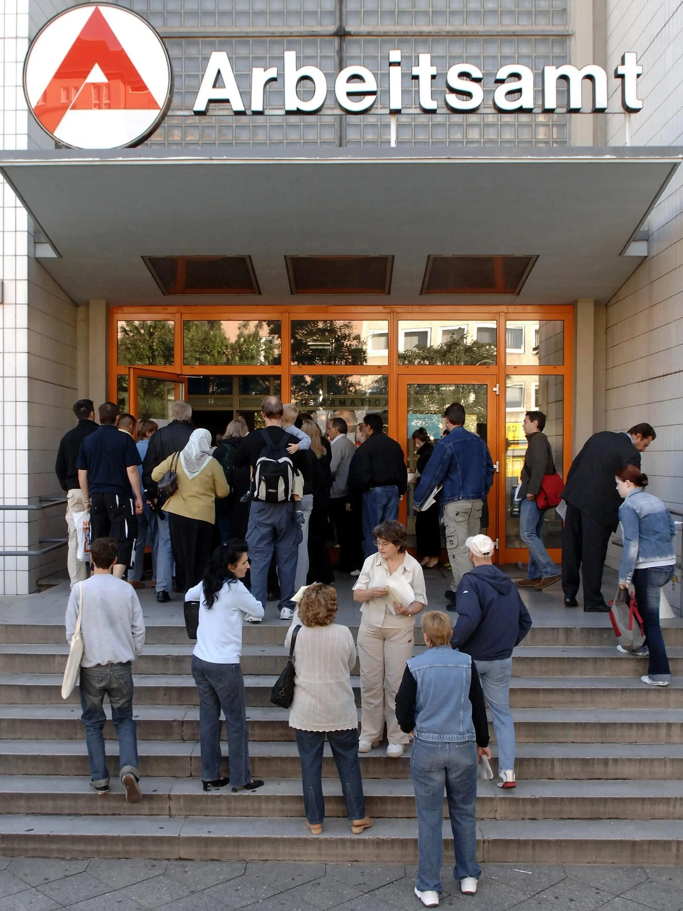 Vor einem Arbeitsamt in Berlin Wedding warten zahlreiche Menschen auf ihren Einlass (Archivfoto vom 08.08.2005). Obwohl die über 4 Millionen Arbeitslosen eines der Hauptthemen im Wahlkampf sind, sehen Meinungsforscher Anzeichen dafür, dass viele von ihnen selber gar nicht zur Wahl gehen werden. Foto: Jan Woitas dpa/lbn (zum dpa-KORR: ""Alle gleich schlecht - Arbeitslose erhoffen sich von Wahl wenig" vom 08.09.2005) +++(c) dpa - Bildfunk+++