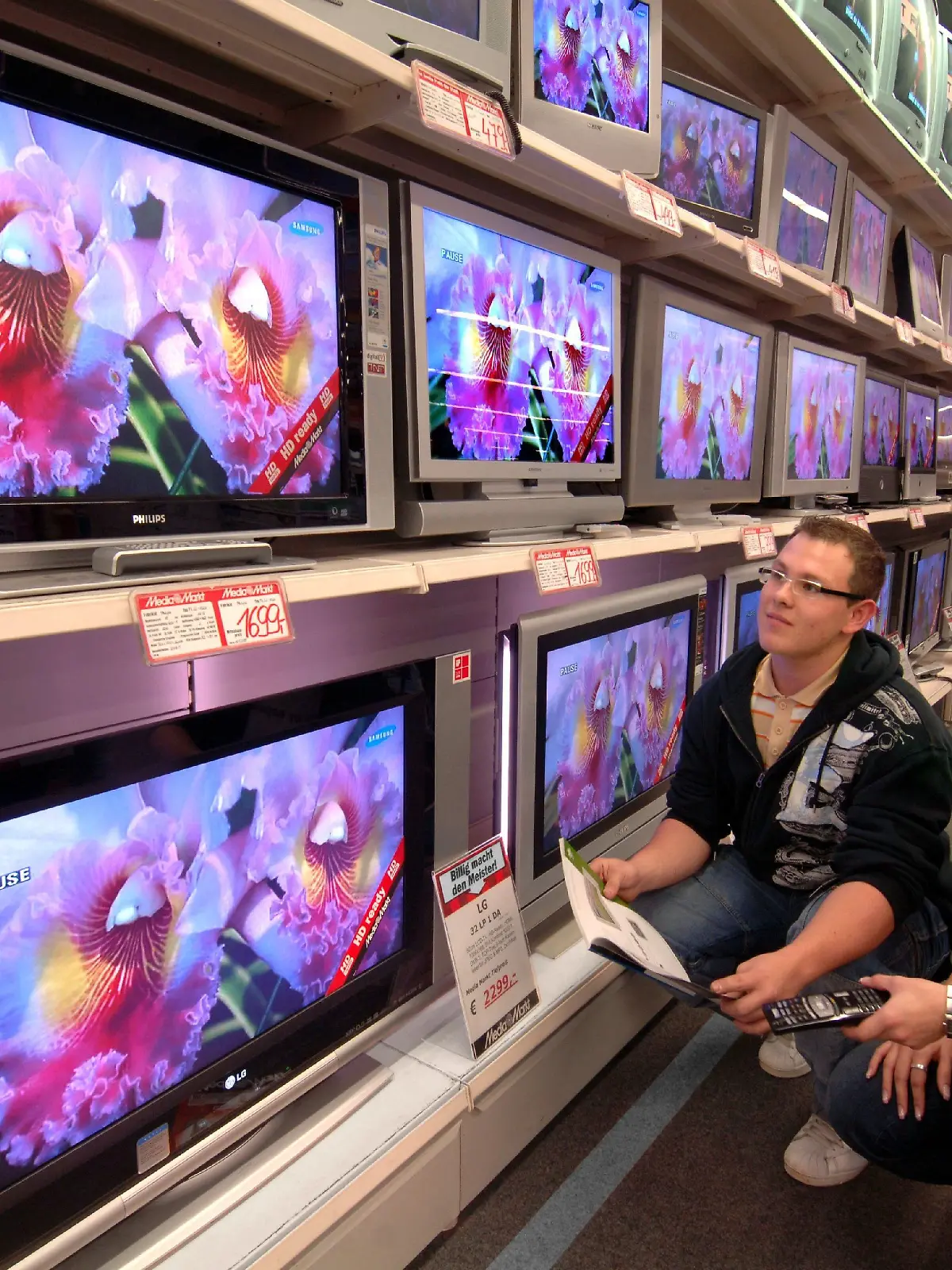Im Media-Markt des Chemnitzer Einkaufszentrums Sachsenallee zeigt Fachberaterin für Unterhaltung Anne Rölke am Mittwoch (09.11.2005) einem Kunden das vielfältige Angebot von Fernsehgeräten mit Flachbildschirmen mit LCD- bzw. Plasma-Technik. Ein Großteil der neuen TV-Geräte ist bereits mit der zukunftorientierten hochauflösenden Technik (HD) ausgerüstet. Bisher besitzen nur rund fünf Prozent der deutschen Haushalte ein TV-Gerät mit Flachbildshirm. Über die Hälfte der Haushalte ist jedoch laut einer Umfrage des Allensbach-Instituts an der innovativen Technik interessiert und plant abhängig von der Preisentwicklung den Kauf eines solchen Gerätes. Foto: Wolfgang Thieme dpa/lsn +++(c) dpa - Bildfunk+++