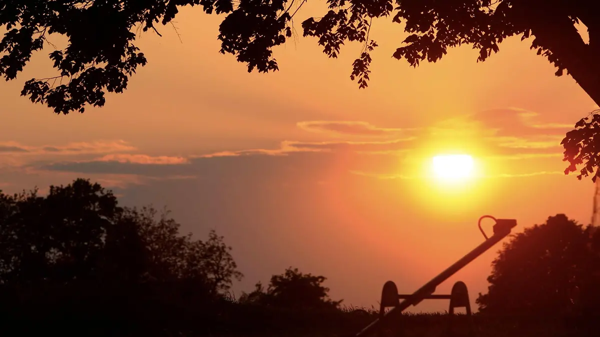 Die Sonne geht am Mittwoch (14.05.2008) hinter einer Kinderwippe bei Lichtenfels (Oberfranken) auf. Laut Wettervorhersage soll ab Donnerstag regnerisch und etwas kühler werden. Foto: Marcus Führer dpa/lby +++(c) dpa - Bildfunk+++