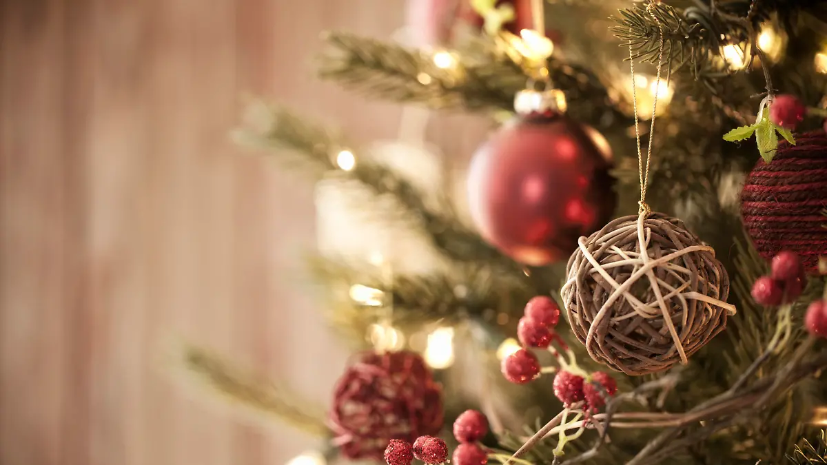 Christmas tree with eco friendly decorations, ornaments and gifts on an old wood background