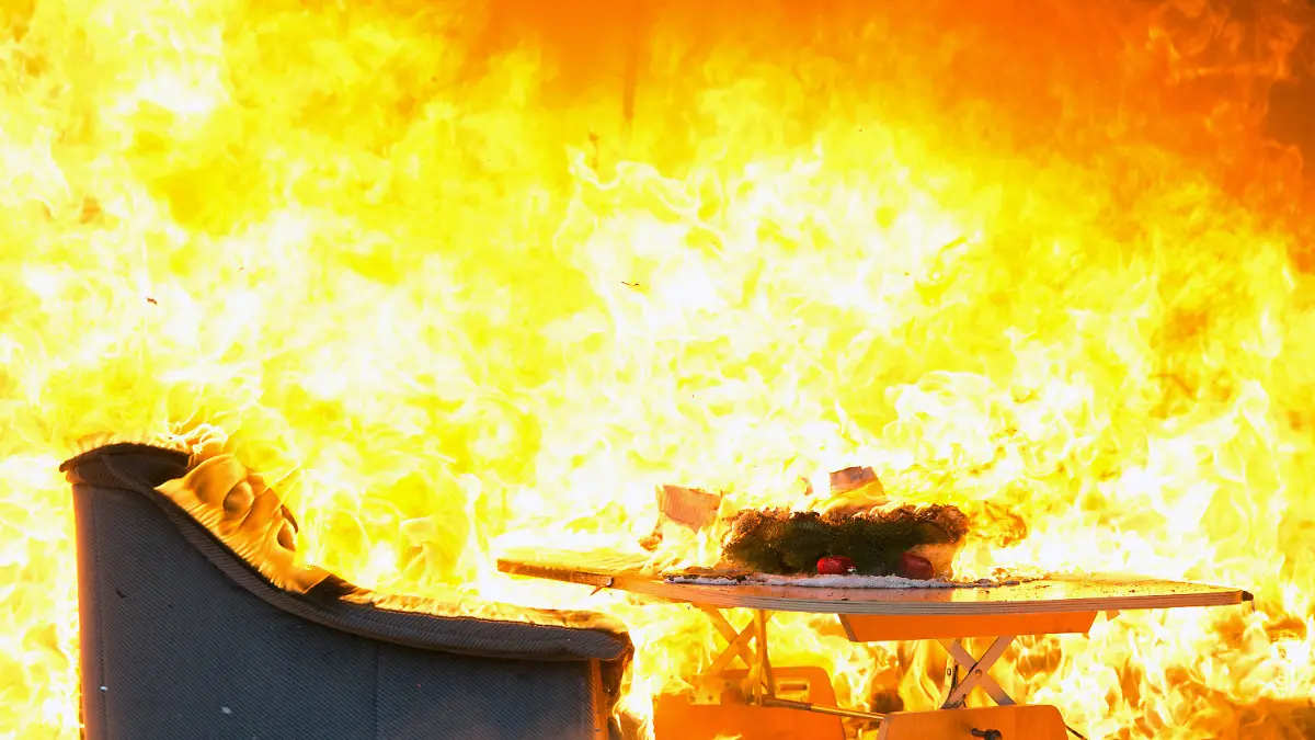 Die Wohnungseinrichtung in einem zu Schauzwecken weihnachtlich hergerichteten Wohnzimmer brennt am 29.11.2013 auf dem Hof der ehemaligen Feuerwache in Mariendorf in Berlin. Die Feuerwehr demonstrierte mit der Vorführung in dem Container die Brandgefahren in der Adventszeit. Foto: Soeren Stache/dpa +++(c) dpa - Bildfunk+++