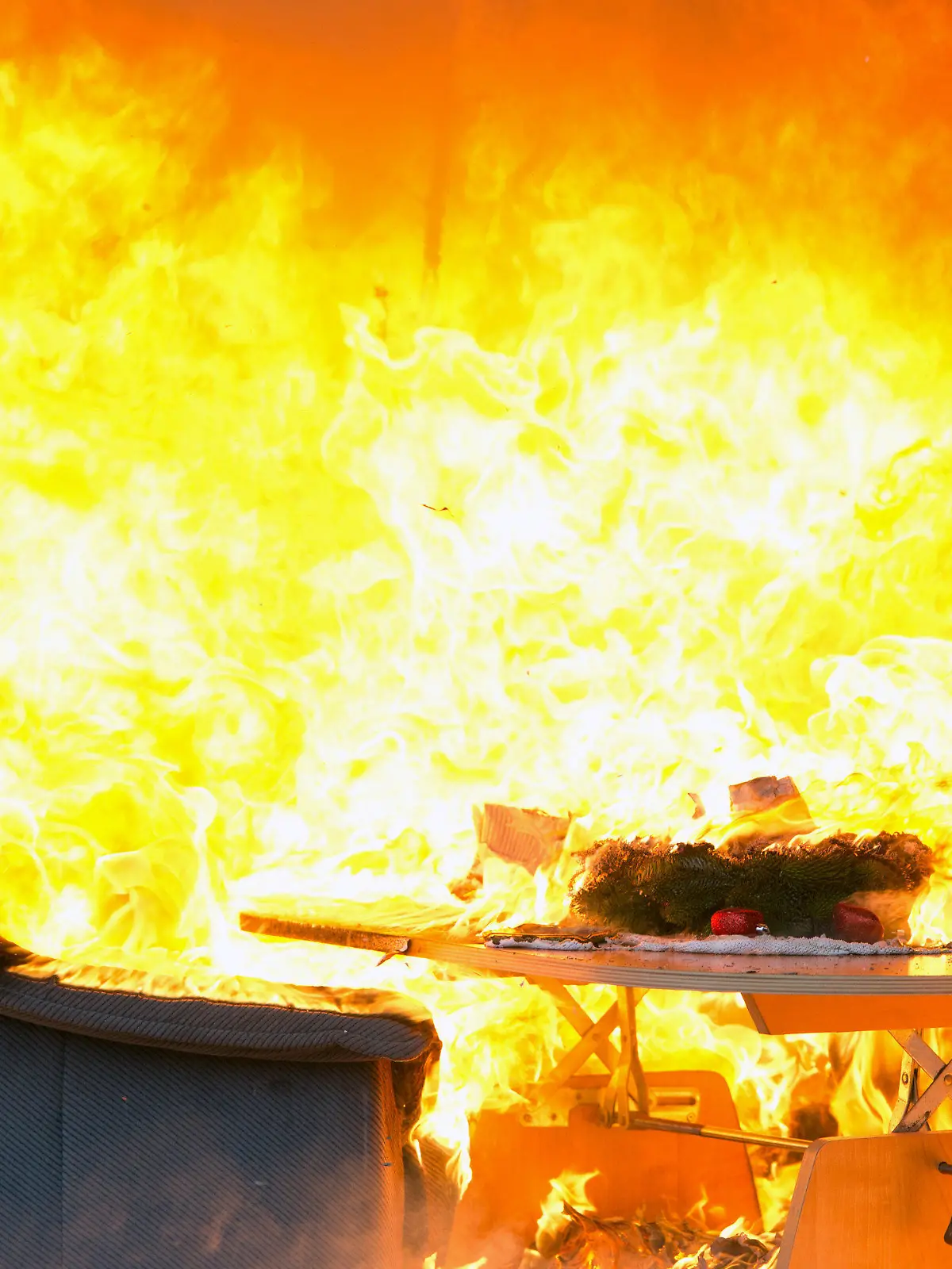 Die Wohnungseinrichtung in einem zu Schauzwecken weihnachtlich hergerichteten Wohnzimmer brennt am 29.11.2013 auf dem Hof der ehemaligen Feuerwache in Mariendorf in Berlin. Die Feuerwehr demonstrierte mit der Vorführung in dem Container die Brandgefahren in der Adventszeit. Foto: Soeren Stache/dpa +++(c) dpa - Bildfunk+++