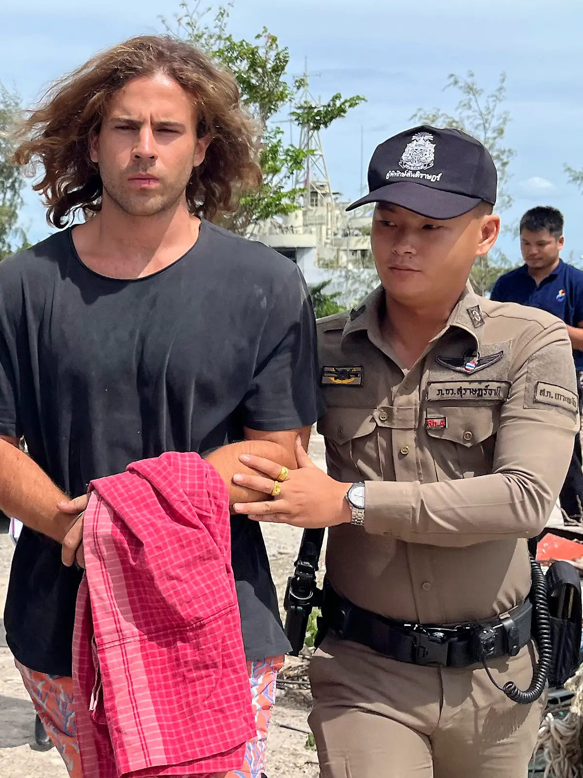 A Thai police officer escorts Spanish Daniel Sancho Bronchalo on suspicion of murdering and dismembering a Colombian surgeon from Koh Phagnan island to Koh Samui Island court, southern Thailand, Monday, Aug. 7, 2023. Sancho, the son of two Spanish film stars, has been arrested in Thailand on suspicion of murdering and dismembering Edwin Arrieta Arteaga on a tourist island, police said. Sancho was taken from Koh Phagnan, where the remains of the Colombian surgeon were found, to another island, Samui, where he is being held, Surat Thani provincial police commander Saranyu Chamnanrat said Tuesday. (AP Photo/Somkeat Ruksaman)