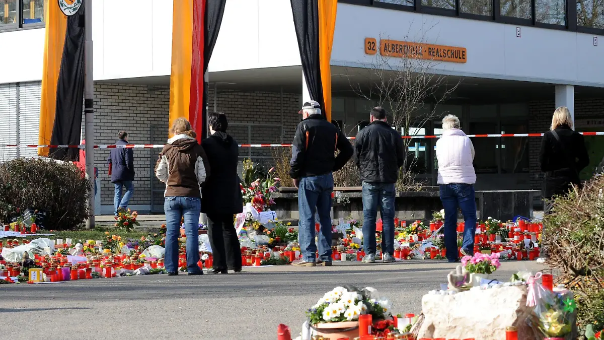 Trauernde stehen am Mittwoch (18.03.2009) vor der Albertville Realschule in Winnenden. Der 17-jährige Tim K. hatte am 11.03.2009 an seiner früheren Schule, der Albertville-Realschule in Winnenden, und auf der Flucht nach Wendlingen fünfzehn Menschen und sich selbst erschossen. Foto: Bernd Weißbrod dpa/lsw +++(c) dpa - Bildfunk+++