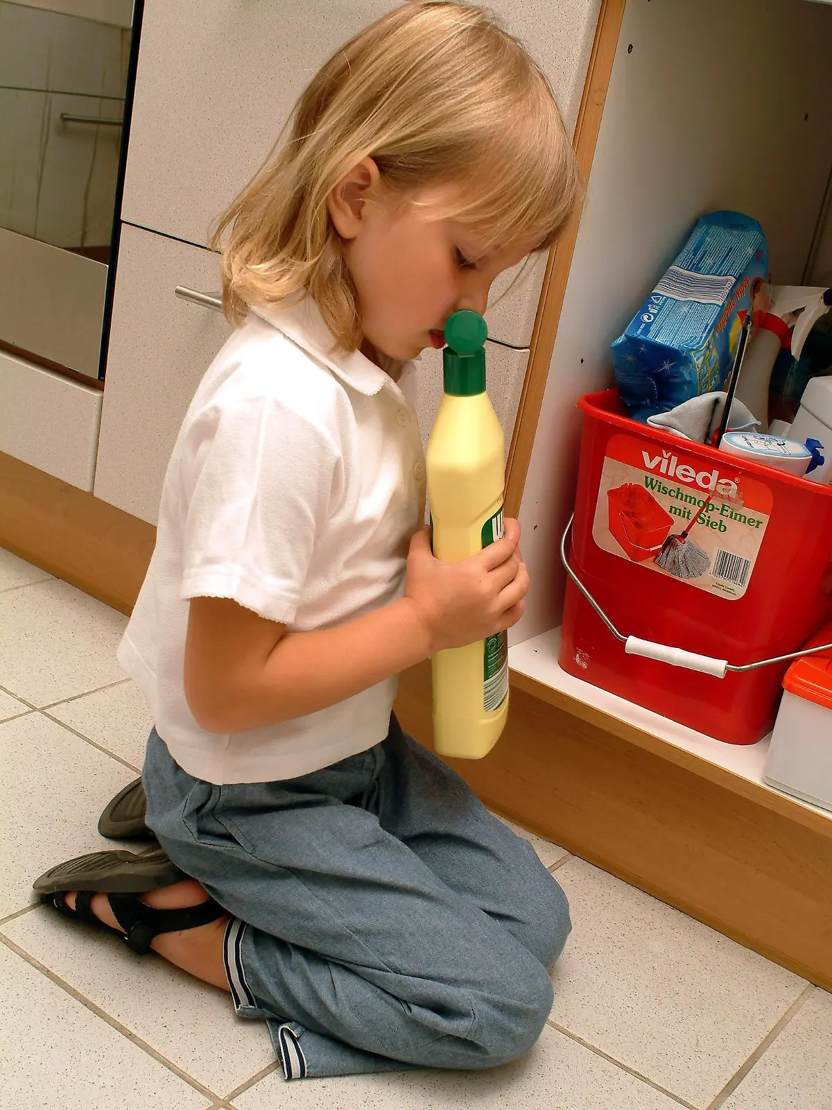 Ein kleines Mädchen räumt neugierig die Putzmittel aus einem Schrank in der Küche und riecht an einer Flascher mit Scheuerpulver, aufgenommen am 20.07.2004 in Glashütten. Foto: Heiko Wolfraum dpa