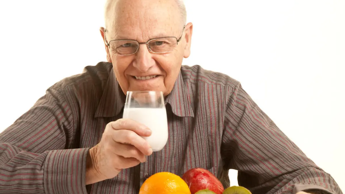 Senior man having a healthy breakfast isolated on white