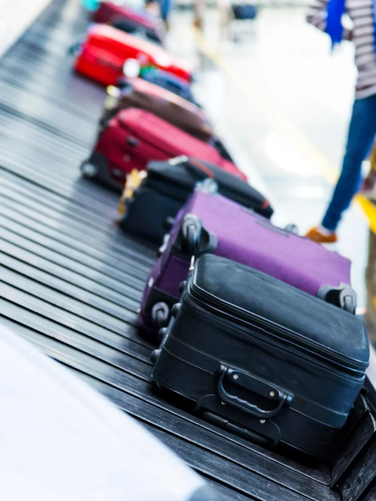 Luggages moving on airport conveyor belt.