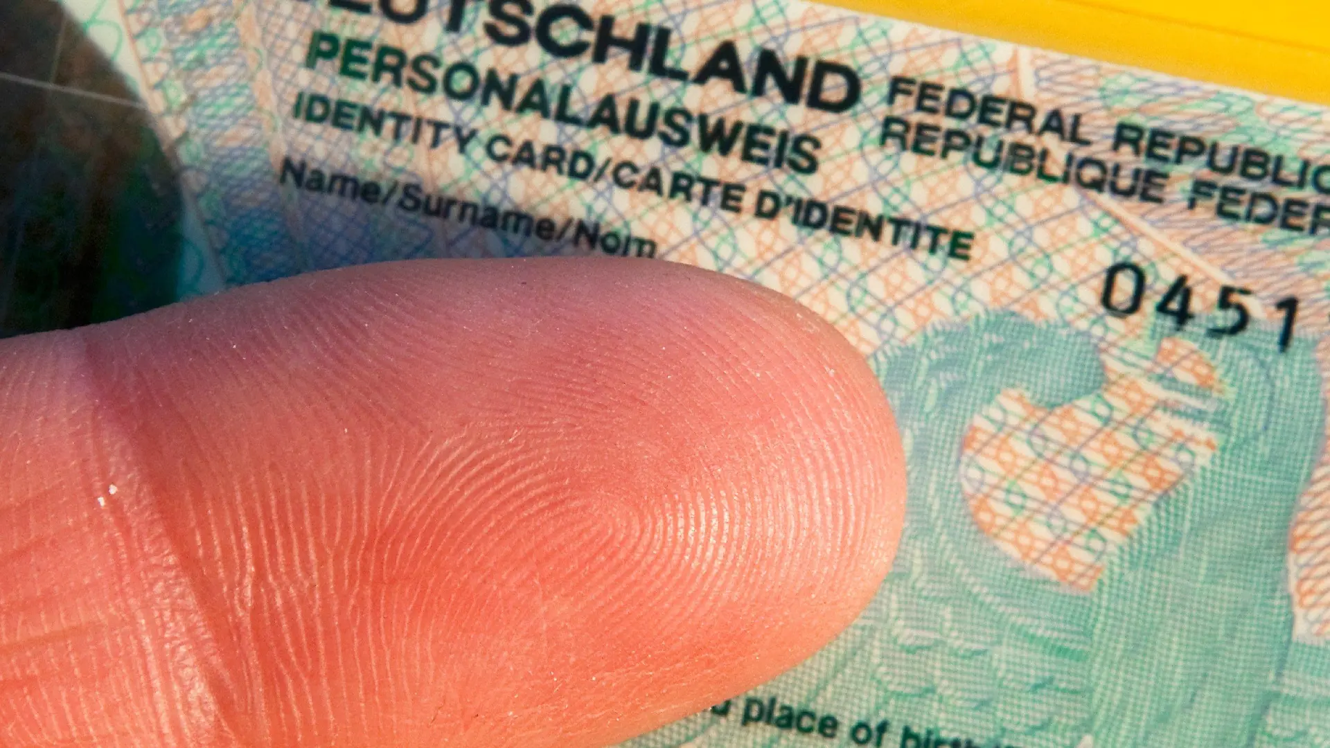 Ein Zeigefinger ist am Donnerstag (12.06.2008) in Schwerin über einem deutschen Personalausweis zu sehen. (Illustration zum Fingerabdrücke auf Personalausweisen) Der Bundesinnenminister ist mit seinem Plan gescheitert, Abdrücke beider Zeigefinger in jedem neuen Personalausweis speichern zu lassen. Das berichtet die «Neue Osnabrücker Zeitung» unter Berufung auf Innenexperten von Union und SPD. Fingerabdrücke sollen demnach nur auf Wunsch im Personalausweis gespeichert werden, eine Speicherpflicht werde es nicht geben. Foto: Jens Büttner dpa/lmv (zu dpa 4297 vom 12.06.2008) +++(c) dpa - Bildfunk+++