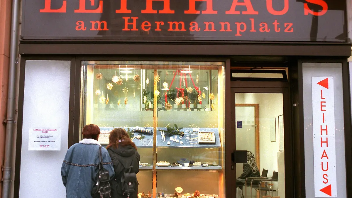 Passanten betrachten am 16.12.1998 die Auslagen im Schaufenster eines Leihhauses in Berlin-Kreuzberg. Besonders in der Vorweihnachtszeit herrscht reges Treiben in den Pfandleihen der Hauptstadt. Gegen Bares werden hier Videorekorder und Fotoapparate getauscht, Uhren und Halscolliers, Besteck und Stereoboxen, Gold oder Silber - vom schlichten Konfirmationsschmuck bis zu schweren Erbstücken. Viele Menschen holen mit dem Weihnachtsgeld ihr Eigentum wieder ab, während sich andere von ihren besten Stücken trennen, um Bargeld für die Festgeschenke zu erhalten. Während die Umsätze der Pfandleiher deutschlandweit um moderate drei Prozent pro Jahr steigen, verzeichnen die 14 Berliner Betriebe schätzungsweise doppelt soviel Wachstum.