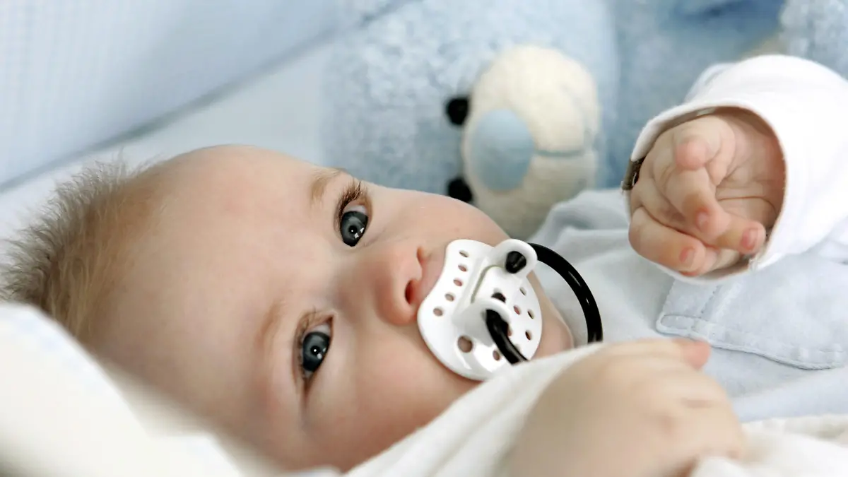A tired baby sucks a dummy in a bed, 11.04.2005. Foto: MARJA AIRIO xMODEL RELEASED +++(c) dpa - Report+++