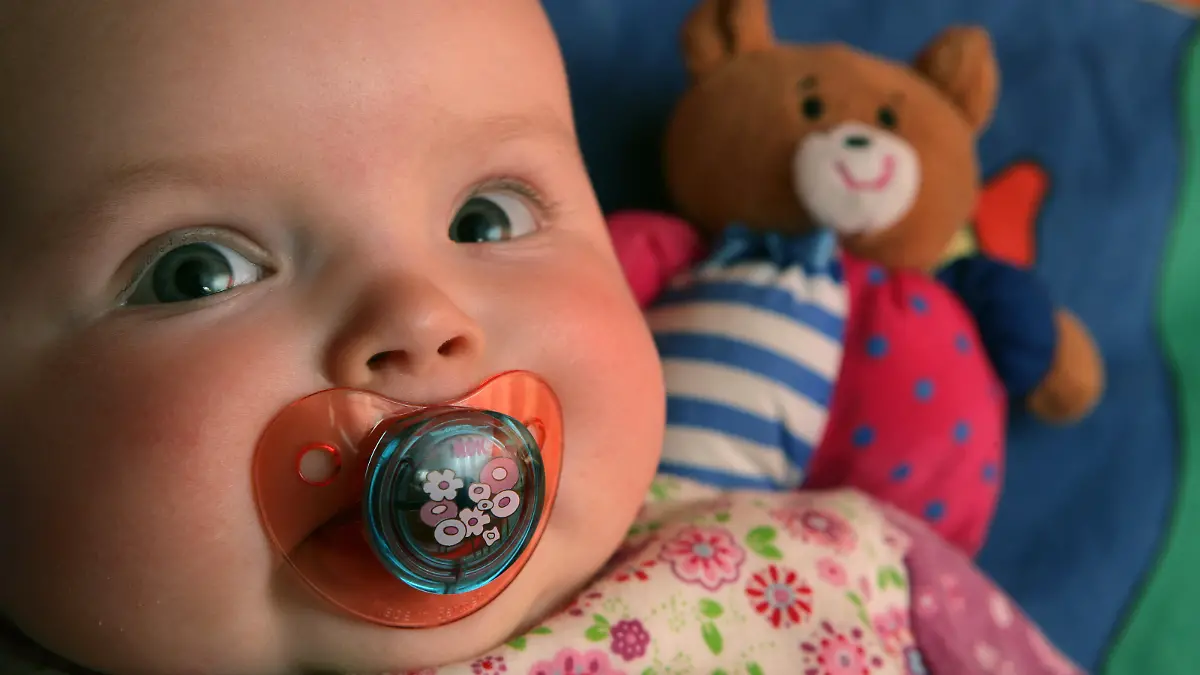 Ein fünf Monate altes Baby hat einen Schnuller im Mund, aufgenommen am 28.02.2007 im brandenburgischen Sieversdorf. Der natürliche Saugreflex der Säuglinge bedingt, dass sich Kleinkinder mit Babysauger im Mund meistens wohl fühlen. Babysauger und Schnuller sind heute von ihrer Materialbeschaffenheit meist bedenkenlos zu geben. Vor dem ersten Gebrauch sollten die Nuckel ausgekocht werden. Auch die Sauger von Trinkflaschen sollten nach jeder Benutzung ausgekocht werden. Dauernuckeln kann allerdings zu Babykarries oder zur Deformation des sich ausbildenden Gebisses führen. Foto: Patrick Pleul +++(c) dpa - Report+++