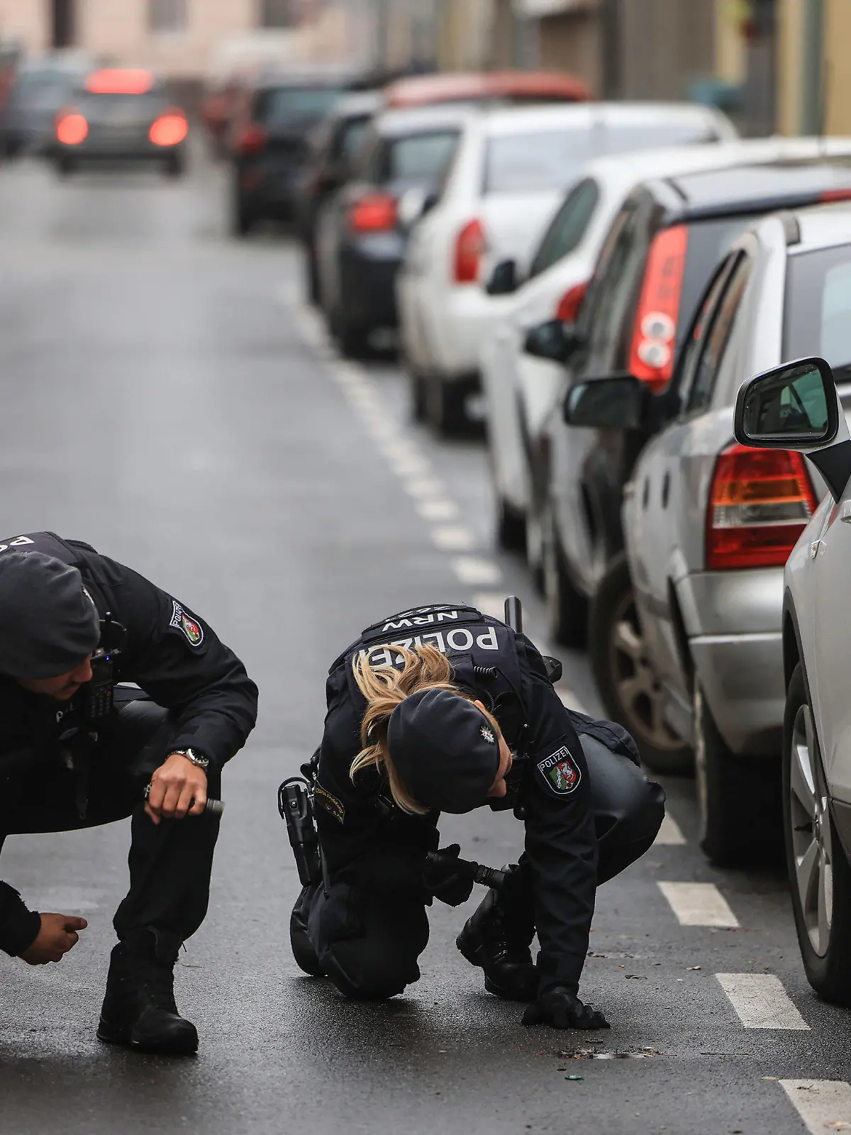 29.11.2022, Nordrhein-Westfalen, Krefeld: Polizisten suchen in der Nähe eines Tatortes nach Spuren. Nach der Erschießung eines 42-Jährigen auf offener Straße fahndet die Mordkommission in Krefeld nach zwei Männern. Foto: Oliver Berg/dpa +++ dpa-Bildfunk +++