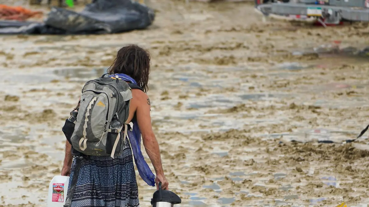 Syndication: Reno Gazette Journal A Burning Man participant makes their way through the mud. , EDITORIAL USE ONLY PUBLICATIONxINxGERxSUIxAUTxONLY Copyright: xTrevorxHughesx 21338295