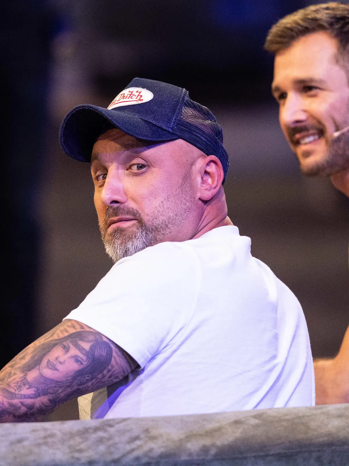 09.08.2019, Nordrhein-Westfalen, Köln: Zlatko (l) sitzt bei der Auftaktshow zur neuen Staffel der Sat.1 Realityshow "Promi Big Brother" auf der Bühne neben Moderator Jochen Schropp.     (zu dpa "Überlänge, TV-Comeback und Abschiedstränen bei «Promi Big Brother»") Foto: Marcel Kusch/dpa +++ dpa-Bildfunk +++