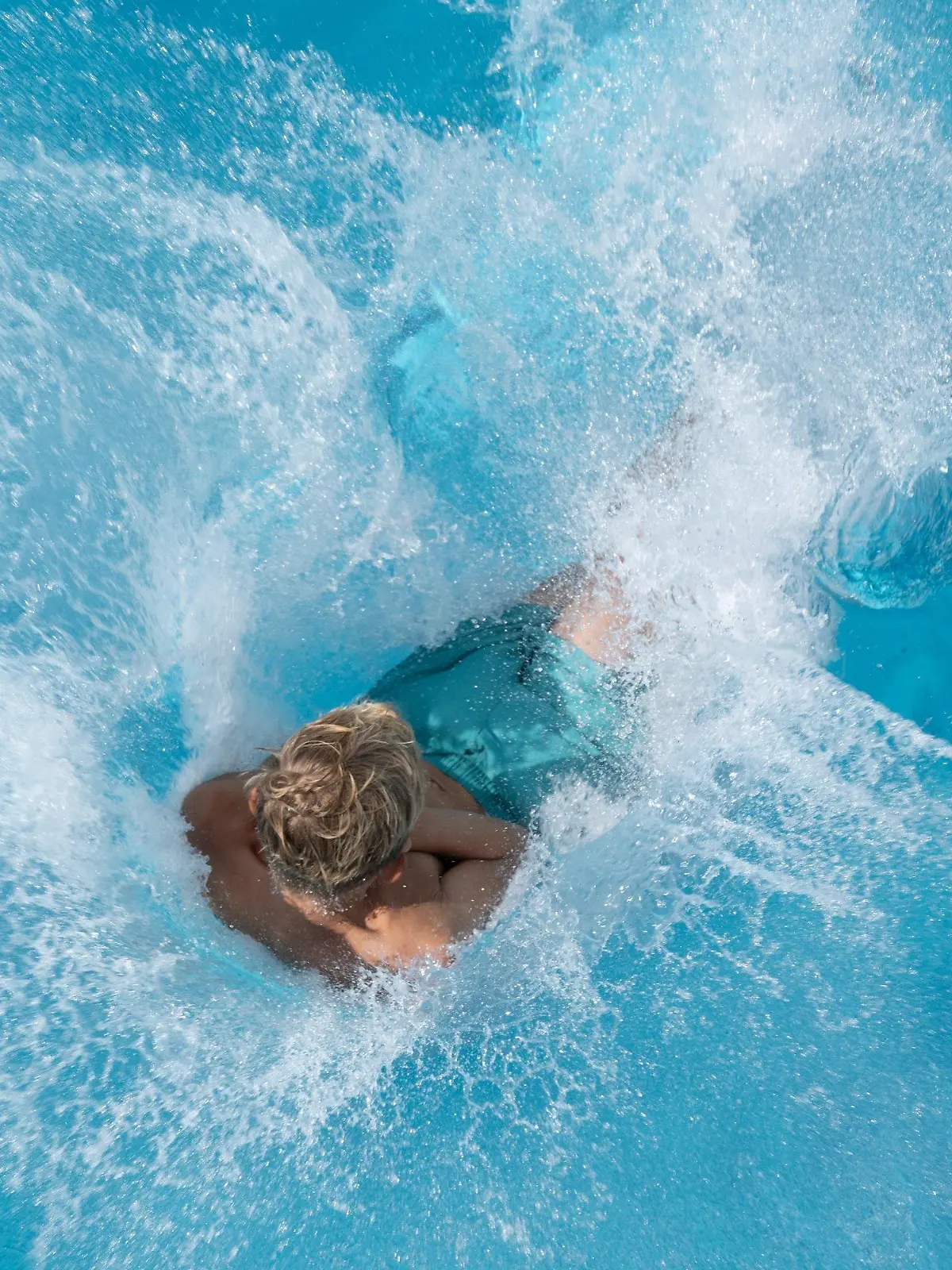 19.08.2023, Sachsen, Dresden: Ein Junge springt im Freibad Wostra vom 5-Meter-Turm ins Wasser. Foto: Sebastian Kahnert/dpa +++ dpa-Bildfunk +++
