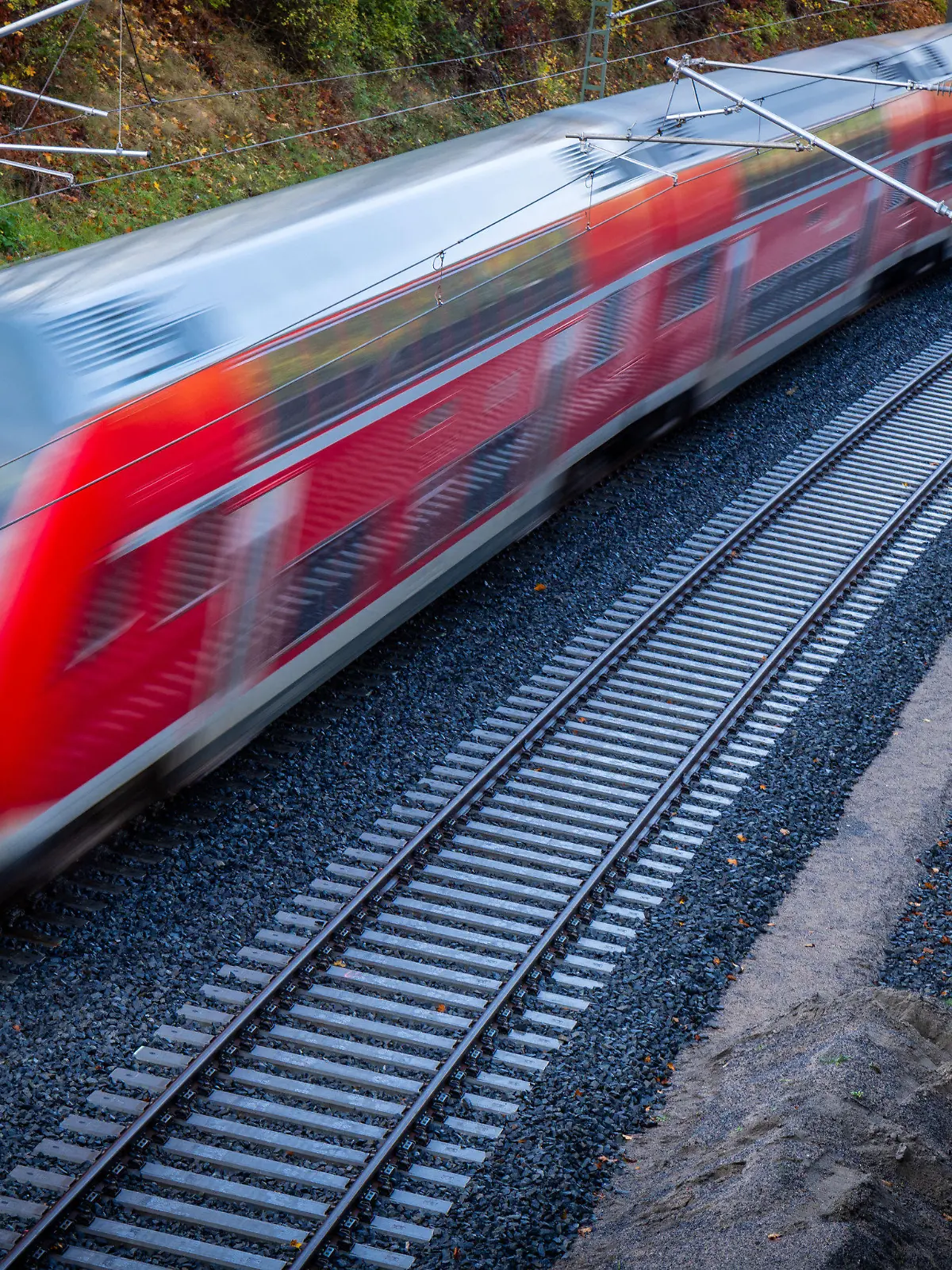 ARCHIV - 28.10.2022, Mecklenburg-Vorpommern, Schwerin: Ein Nahverkehrszug fährt über die neu gebaute Bahnstrecke zum Schweriner Hauptbahnhof (Aufnahme mit langer Belichtungszeit). (zu dpa «Landesseniorenbeirat sieht geplantes 365-Euro-Ticket in MV kritisch») Foto: Jens Büttner/dpa +++ dpa-Bildfunk +++