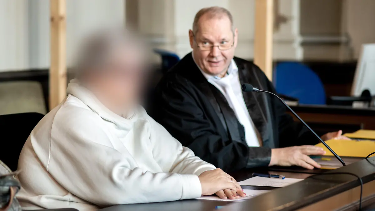 07.11.2022, Niedersachsen, Verden: Die angeklagte Frau sitzt vor Prozessbeginn neben ihrem Anwalt Thorsten Osterkamp in einem Gerichtssaal im Landgericht Verden. Die Hebamme ist wegen Körperverletzung mit Todesfolge angeklagt. Sie betreute im Januar 2015 eine schwangere Frau während einer mehrtägigen Hausgeburt, bei der es zu Komplikationen gekommen ist. Dabei soll die Hebamme erkannt haben, dass es der schwangeren Frau und dem Baby zunehmend schlechter gegangen sei und das Leben des Babys ohne ärztliche Hilfe gefährdet sein könnte. Foto: Hauke-Christian Dittrich/dpa - ACHTUNG: Person(en) wurde(n) aus rechtlichen Gründen gepixelt +++ dpa-Bildfunk +++
