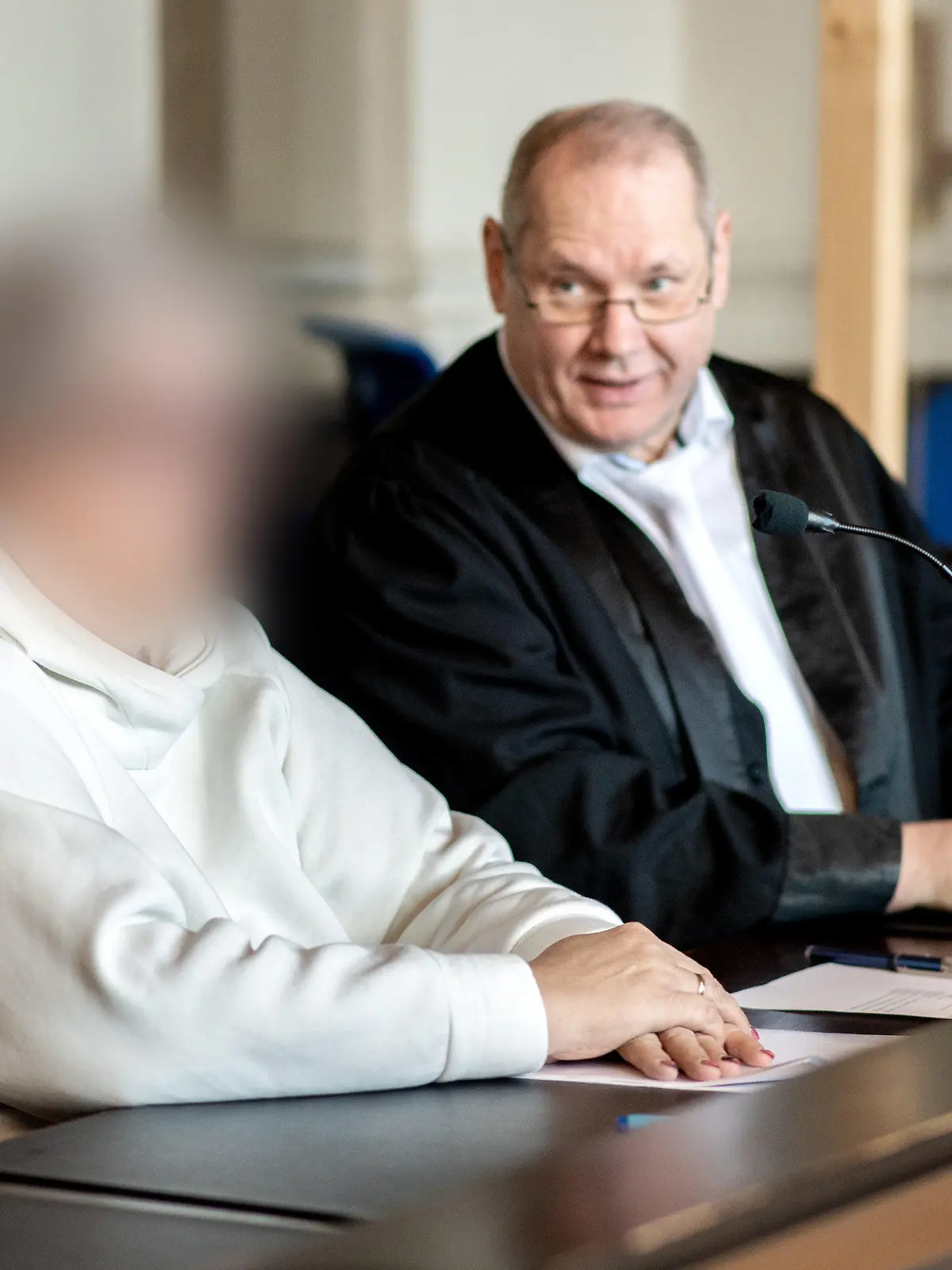 07.11.2022, Niedersachsen, Verden: Die angeklagte Frau sitzt vor Prozessbeginn neben ihrem Anwalt Thorsten Osterkamp in einem Gerichtssaal im Landgericht Verden. Die Hebamme ist wegen Körperverletzung mit Todesfolge angeklagt. Sie betreute im Januar 2015 eine schwangere Frau während einer mehrtägigen Hausgeburt, bei der es zu Komplikationen gekommen ist. Dabei soll die Hebamme erkannt haben, dass es der schwangeren Frau und dem Baby zunehmend schlechter gegangen sei und das Leben des Babys ohne ärztliche Hilfe gefährdet sein könnte. Foto: Hauke-Christian Dittrich/dpa - ACHTUNG: Person(en) wurde(n) aus rechtlichen Gründen gepixelt +++ dpa-Bildfunk +++