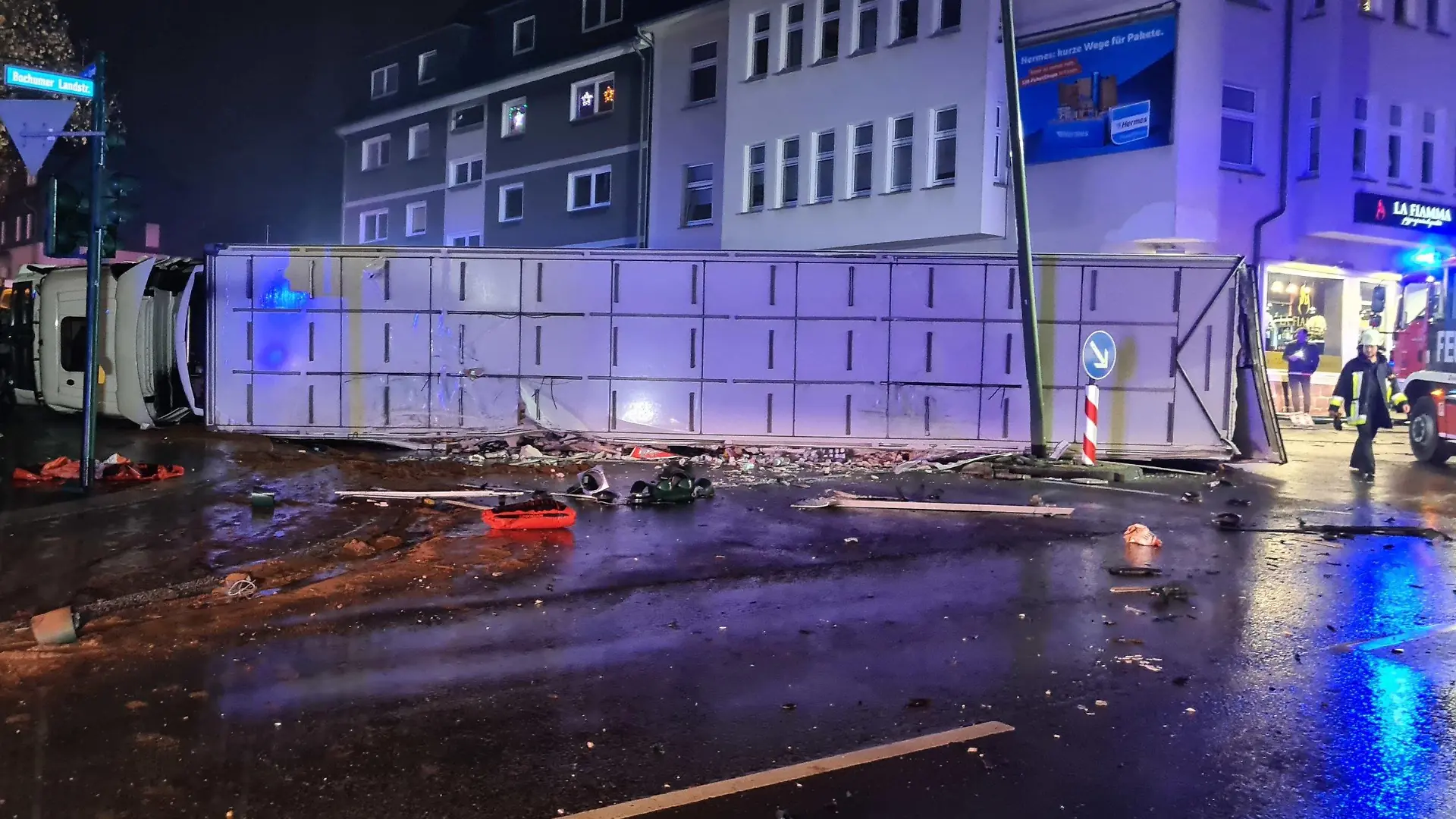 dpatopbilder - 28.11.2022, Nordrhein-Westfalen, Essen: Ein Lastwagenfahrer hat die Kontrolle über seinen 40-Tonner verloren und ist mit mit mehreren Autos und einem Linienbus zusammengestoßen. Das mit Lebensmitteln beladene Fahrzeug sei anschließend auf die Seite gekippt, sagte ein Feuerwehrsprecher. Dabei begrub der Lastwagen ein Auto halb unter sich. (zu dpa "Fünf Verletzte in Essen - Lastwagen kracht in Autos und Linienbus") Foto: Markus Gayk/dpa +++ dpa-Bildfunk +++