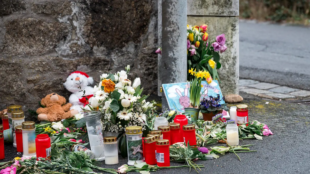ARCHIV - 12.04.2023, Bayern, Wunsiedel: An einer Mauer vor dem Kinder- und Jugendhilfezentrum, in dem eine Zehnjährige tot aufgefunden wurde, liegen Blumen, Kuscheltiere und Kerzen. (zu dpa: «Totes Mädchen in Wunsiedel - Mann wegen Vergewaltigung angeklagt») Foto: Daniel Vogl/dpa +++ dpa-Bildfunk +++