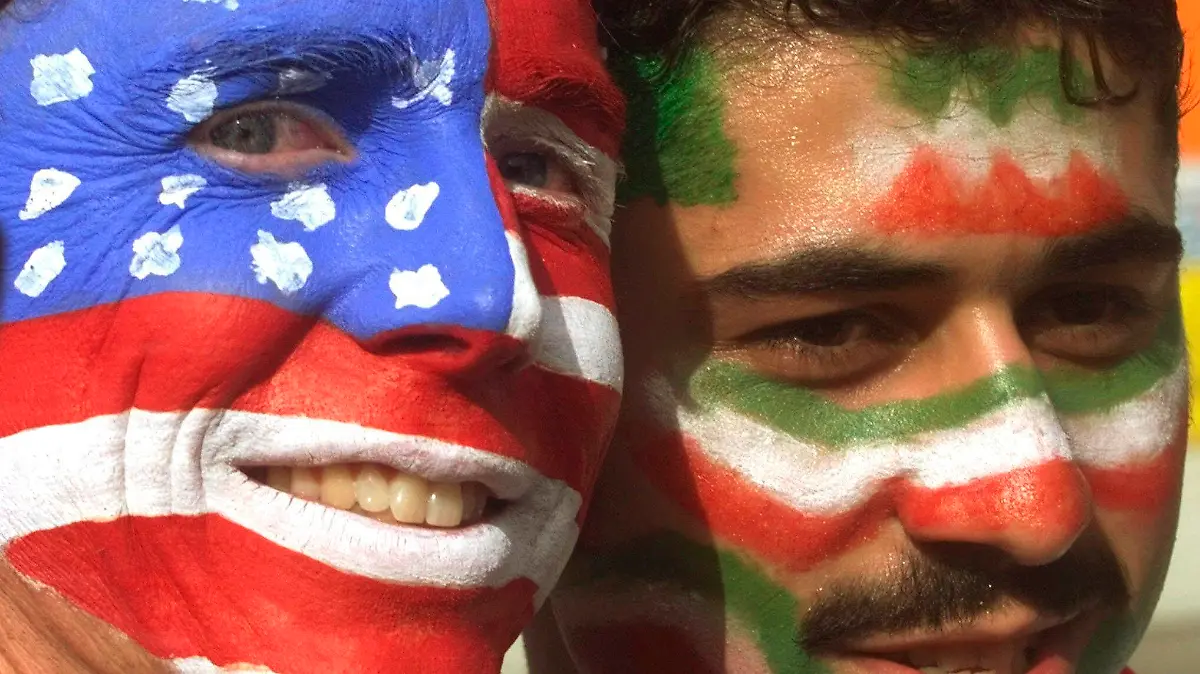 FILE - Mike Moscrop, left, from Orange County, Calif., poses with Amir Sieidoust, an Iranian supporter living in Holland outside the Gerlain Stadium in Lyon, June 21, 1998, before the start of the USA vs Iran World Cup soccer match. Iran defeated the U.S. 2-1 for its first World Cup win, eliminating them after just two games. A rematch between the U.S. and Iran will be played, Tuesday, Nov. 29, 2022. (AP Photo/Jerome Delay)