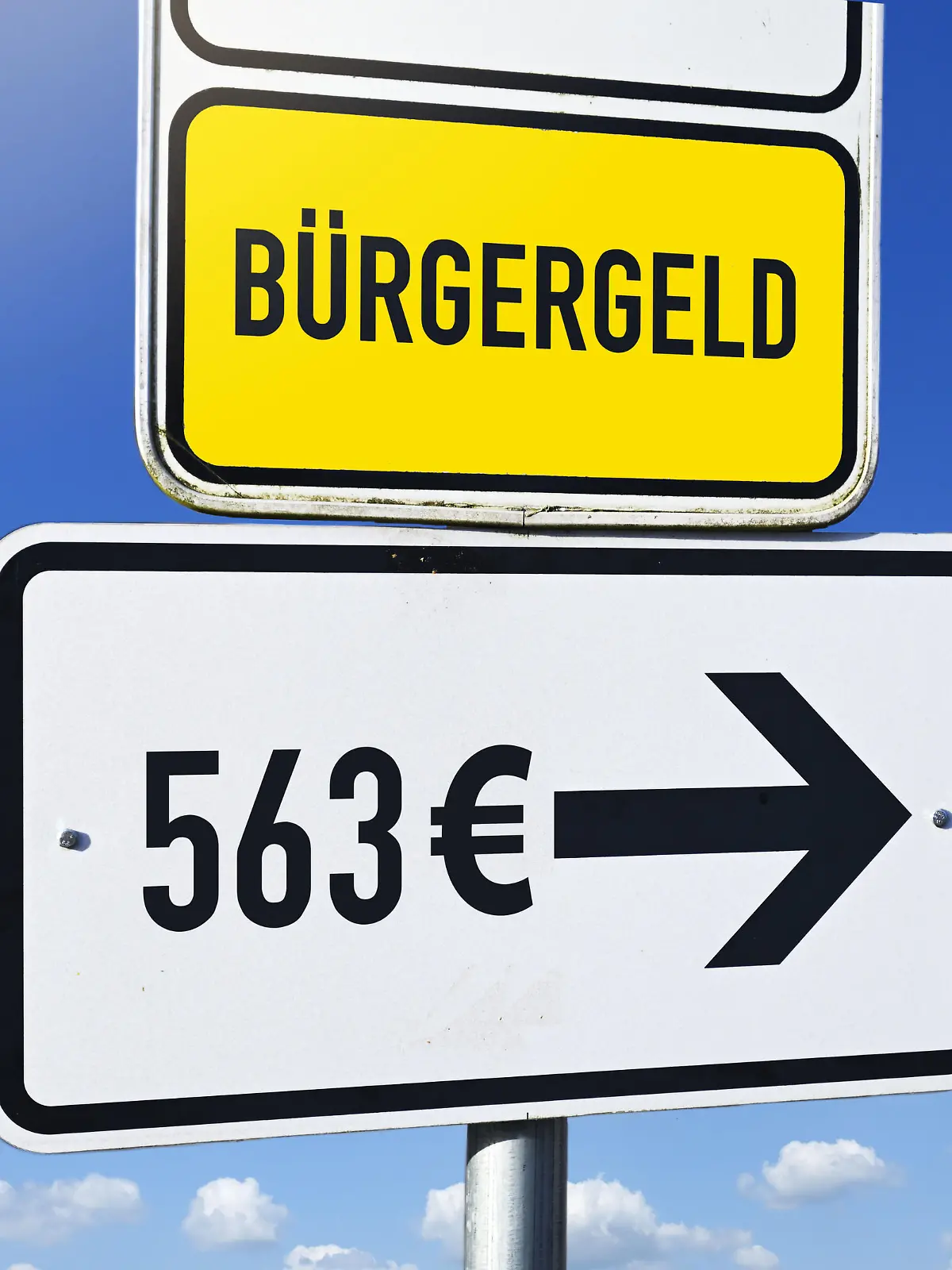 Schild mit Aufschrift Bürgergeld und Wegweiser mit Aufschrift 563 Euro, Erhöhung des Bürgergeldes, Fotomontage