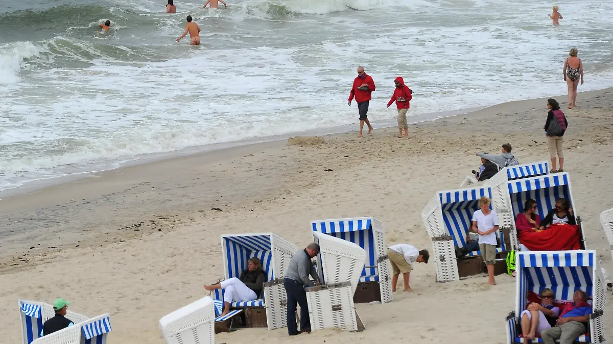 Bei starkem Seegang und nur kurzen Sonnenphasen wagen sich wenige Mutige am Samstag (30.07.2011) in Kampen auf Sylt in das 18 Grad kühle Wasser. Das Wetter im Norden bleibt wechselhaft und unbeständig. Foto: Jens Kalaene dpa/lbn | Verwendung weltweit