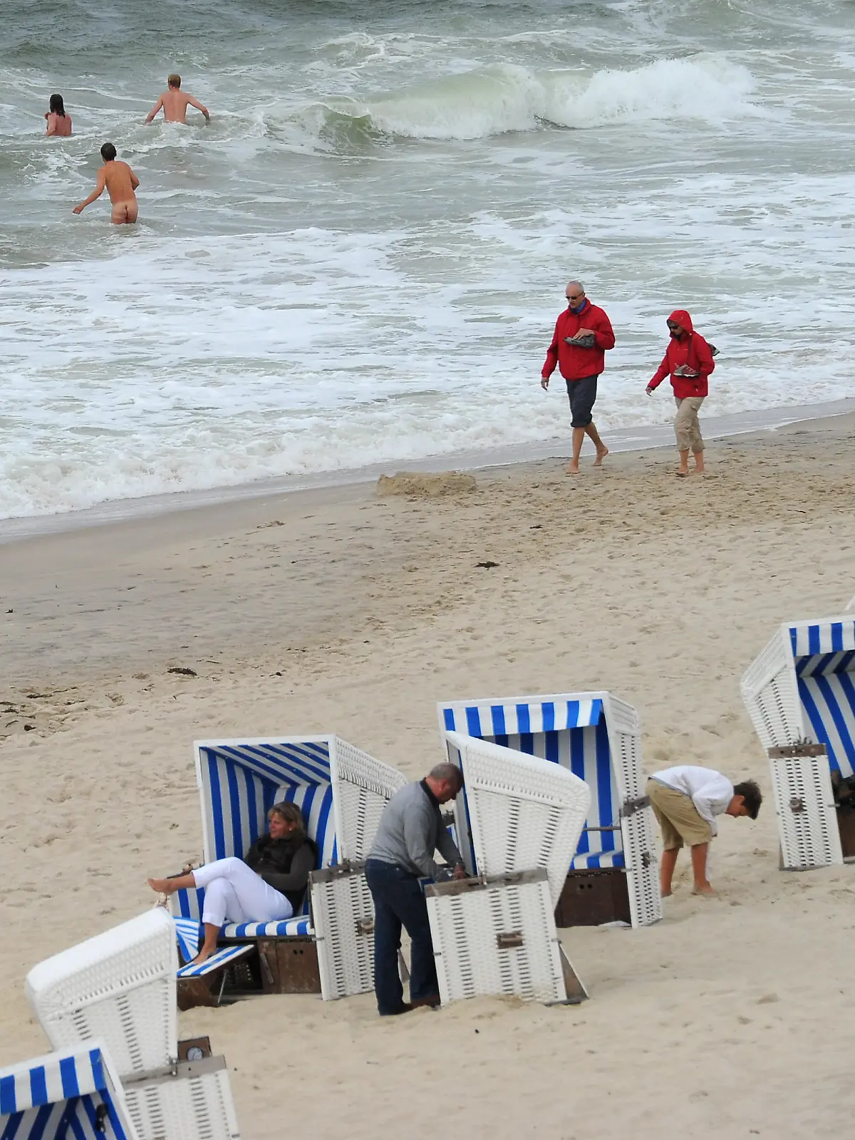 Bei starkem Seegang und nur kurzen Sonnenphasen wagen sich wenige Mutige am Samstag (30.07.2011) in Kampen auf Sylt in das 18 Grad kühle Wasser. Das Wetter im Norden bleibt wechselhaft und unbeständig. Foto: Jens Kalaene dpa/lbn | Verwendung weltweit