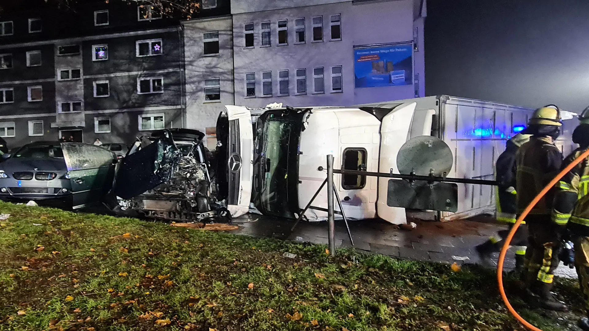 28.11.2022, Nordrhein-Westfalen, Essen: Ein Lastwagenfahrer hat die Kontrolle über seinen 40-Tonner verloren und ist mit mit mehreren Autos und einem Linienbus zusammengestoßen. Das mit Lebensmitteln beladene Fahrzeug sei anschließend auf die Seite gekippt, sagte ein Feuerwehrsprecher. Dabei begrub der Lastwagen ein Auto halb unter sich. (zu dpa "Fünf Verletzte in Essen - Lastwagen kracht in Autos und Linienbus") Foto: Markus Gayk/dpa - ACHTUNG: Kennzeichen wurde aus rechtlichen Gründen gepixelt +++ dpa-Bildfunk +++