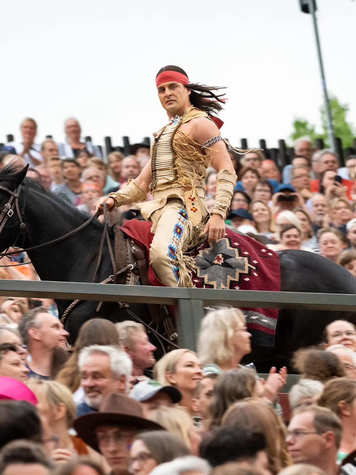 ARCHIV - 24.06.2023, Schleswig-Holstein, Bad Segeberg: Alexander Klaws als Winnetou reitet auf einem Pferd während der Premiere "Winnetou I - Blutsbrüder" der 70. Saison der Karl-May-Spiele in Bad Segeberg durch das Publikum. (zu dpa: «Karl-May-Spiele in Bad Segeberg enden mit Besucherrekord») Foto: Jonas Walzberg/dpa +++ dpa-Bildfunk +++