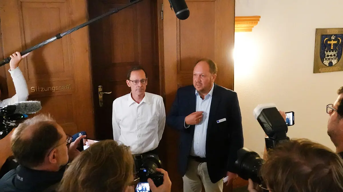 06.09.2023, Schleswig-Holstein, Eutin: Hans Kemeny (l), Vertreter der Pflegeeltern, und Landrat Timo Gaarz (CDU), informieren die Medienvertreter über die Ergebnisse eines Treffens in der Kreisverwaltung Ostholstein. Landrat Gaarz hat dort mit den Pflegeeltern von vier vietnamesischen Kindern über die zuvor geplante Abschiebung der Kinder gesprochen. Der Kreis Ostholstein hat deren Abschiebung nach Vietnam vorerst ausgesetzt. Gegen die Abschiebung wurde eine Online-Petition gestartet, die bisher mehr als 71.000 Menschen unterzeichnet haben. Der Vater der Kinder hatte im Oktober 2022 vor den Augen seines Nachwuchses seine Ehefrau getötet. Foto: Franziska Spiecker/dpa +++ dpa-Bildfunk +++