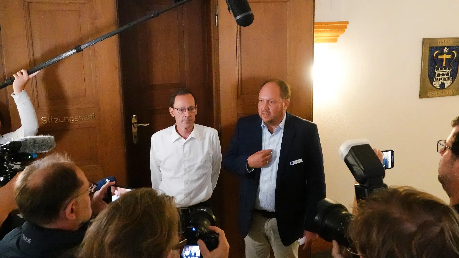 06.09.2023, Schleswig-Holstein, Eutin: Hans Kemeny (l), Vertreter der Pflegeeltern, und Landrat Timo Gaarz (CDU), informieren die Medienvertreter über die Ergebnisse eines Treffens in der Kreisverwaltung Ostholstein. Landrat Gaarz hat dort mit den Pflegeeltern von vier vietnamesischen Kindern über die zuvor geplante Abschiebung der Kinder gesprochen. Der Kreis Ostholstein hat deren Abschiebung nach Vietnam vorerst ausgesetzt. Gegen die Abschiebung wurde eine Online-Petition gestartet, die bisher mehr als 71.000 Menschen unterzeichnet haben. Der Vater der Kinder hatte im Oktober 2022 vor den Augen seines Nachwuchses seine Ehefrau getötet. Foto: Franziska Spiecker/dpa +++ dpa-Bildfunk +++