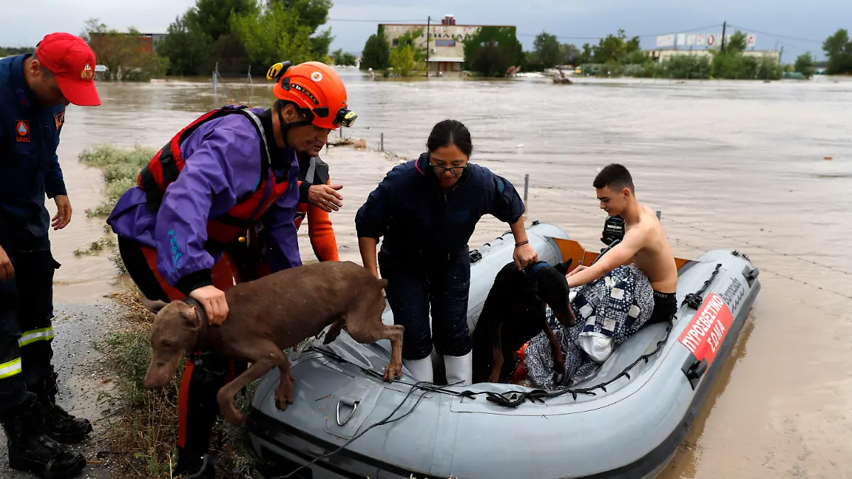 06.09.2023, Griechenland, Larissa: Feuerwehrleute mit einem Schlauchboot evakuieren Menschen und ihre Hunde aus überfluteten Gebäuden. Am 05.09.2023 waren nach einem Unwetter in der Westtürkei nahe der Grenze zu Griechenland und Bulgarien zwei Menschen ums Leben gekommen. Foto: Vaggelis Kousioras/AP/dpa +++ dpa-Bildfunk +++