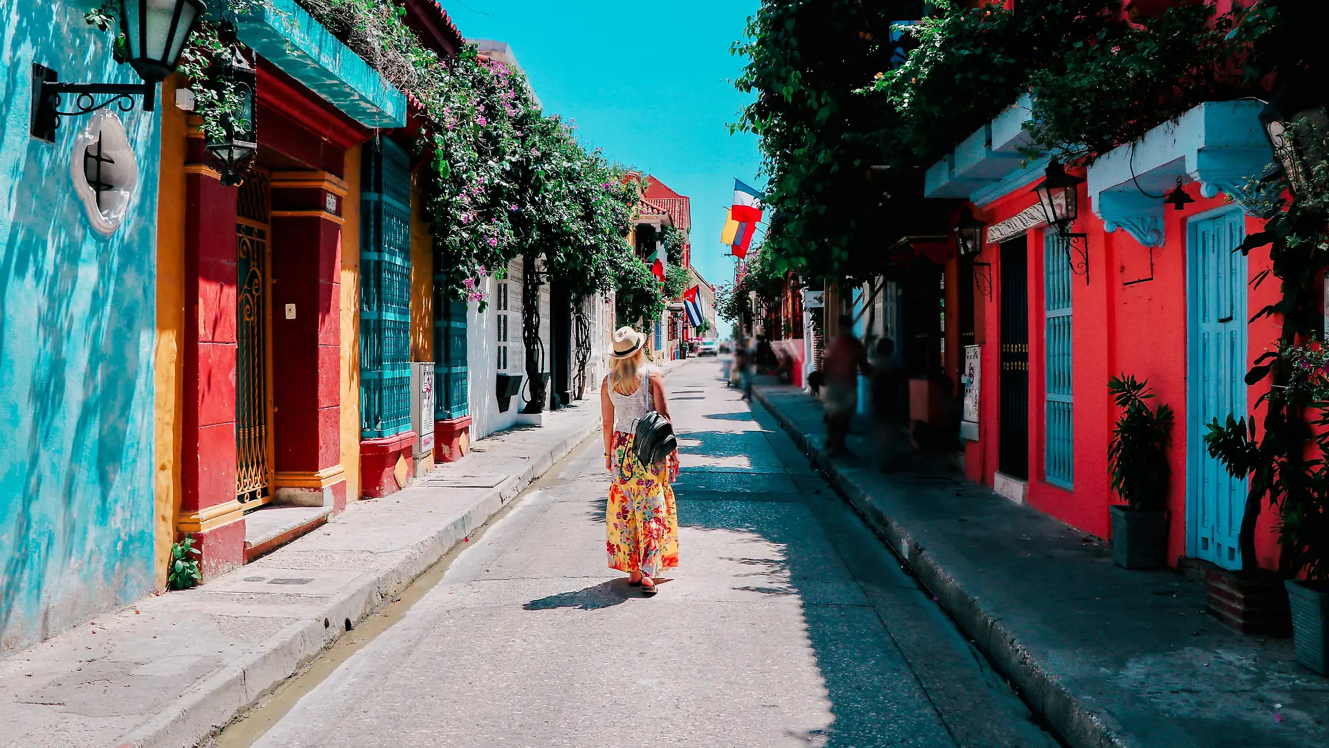 Young woman walking on a colorful street in old city of Cartagena, Colombia