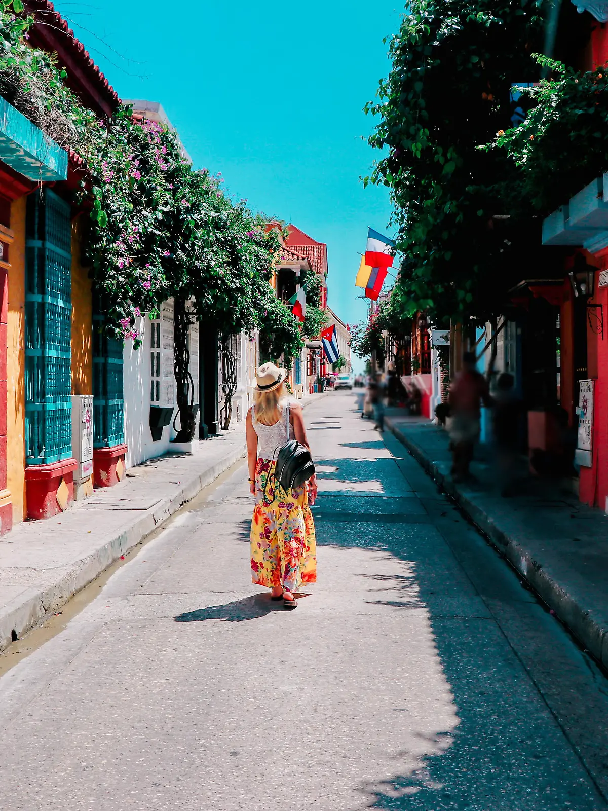 Young woman walking on a colorful street in old city of Cartagena, Colombia