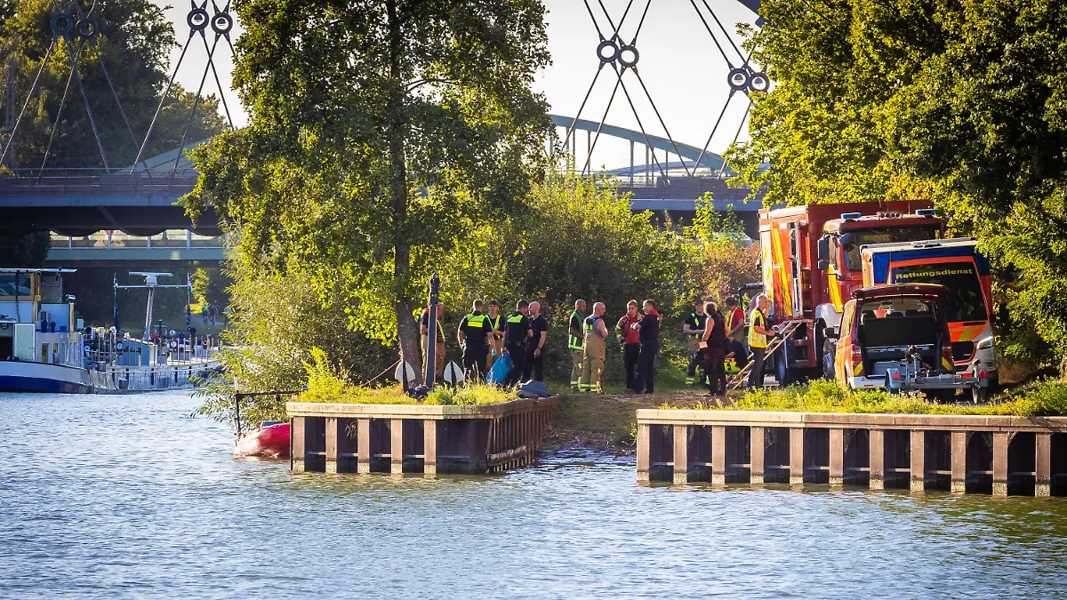06.09.2023, Niedersachsen, Hannover: Einsatzkräfte von Polizei, Feuerwehr und Rettungsdienst stehen am Mittellandkanal in Hannover-Vinnhorst. Bei einem Wasserrettungseinsatz der Feuerwehr Hannover wurde ein 23-Jähriger am Abend aus dem Wasser geborgen, konnte an Land aber nicht wiederbelebt werden, wie ein Feuerwehrsprecher bestätigte. Foto: Moritz Frankenberg/dpa +++ dpa-Bildfunk +++