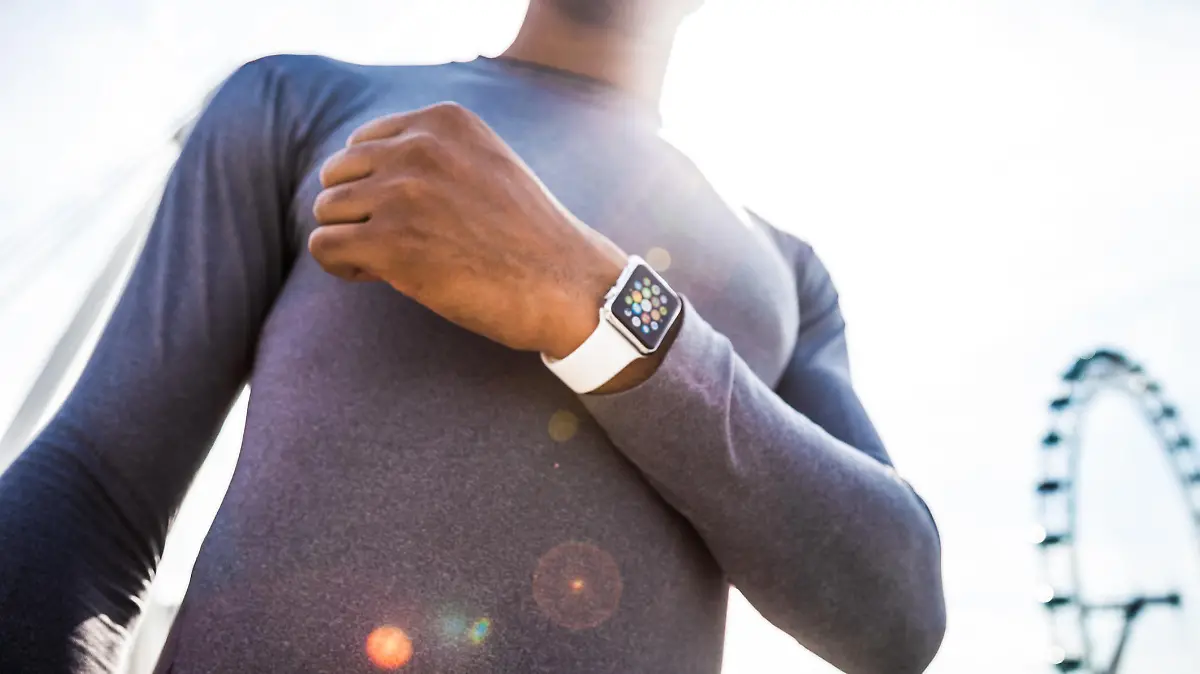 London, United Kingdom - September 7, 2015: Healthy man wearing a 38mm stainless steel Apple Watch with white sports band close to London Eye before the start of a run.
