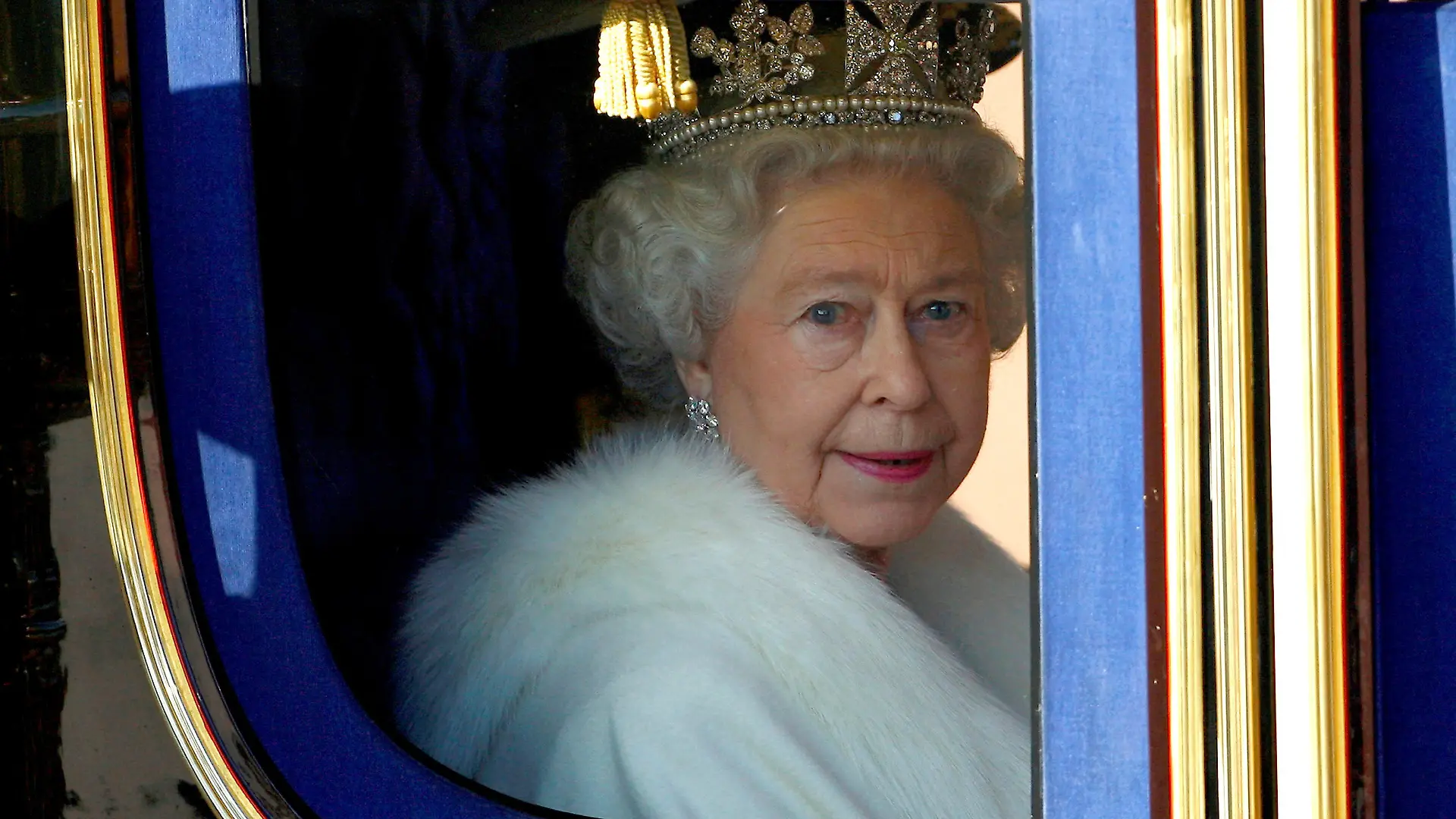 FILE PHOTO: Britain's Queen Elizabeth looks out from her horse drawn carriage as she is driven from Buckingham Palace to the Palace of Westminster for the traditional opening of Parliament in London November 6, 2007.    REUTERS/Dylan Martinez/File Photo