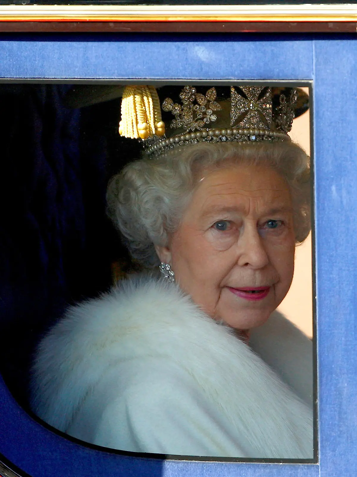 FILE PHOTO: Britain's Queen Elizabeth looks out from her horse drawn carriage as she is driven from Buckingham Palace to the Palace of Westminster for the traditional opening of Parliament in London November 6, 2007.    REUTERS/Dylan Martinez/File Photo