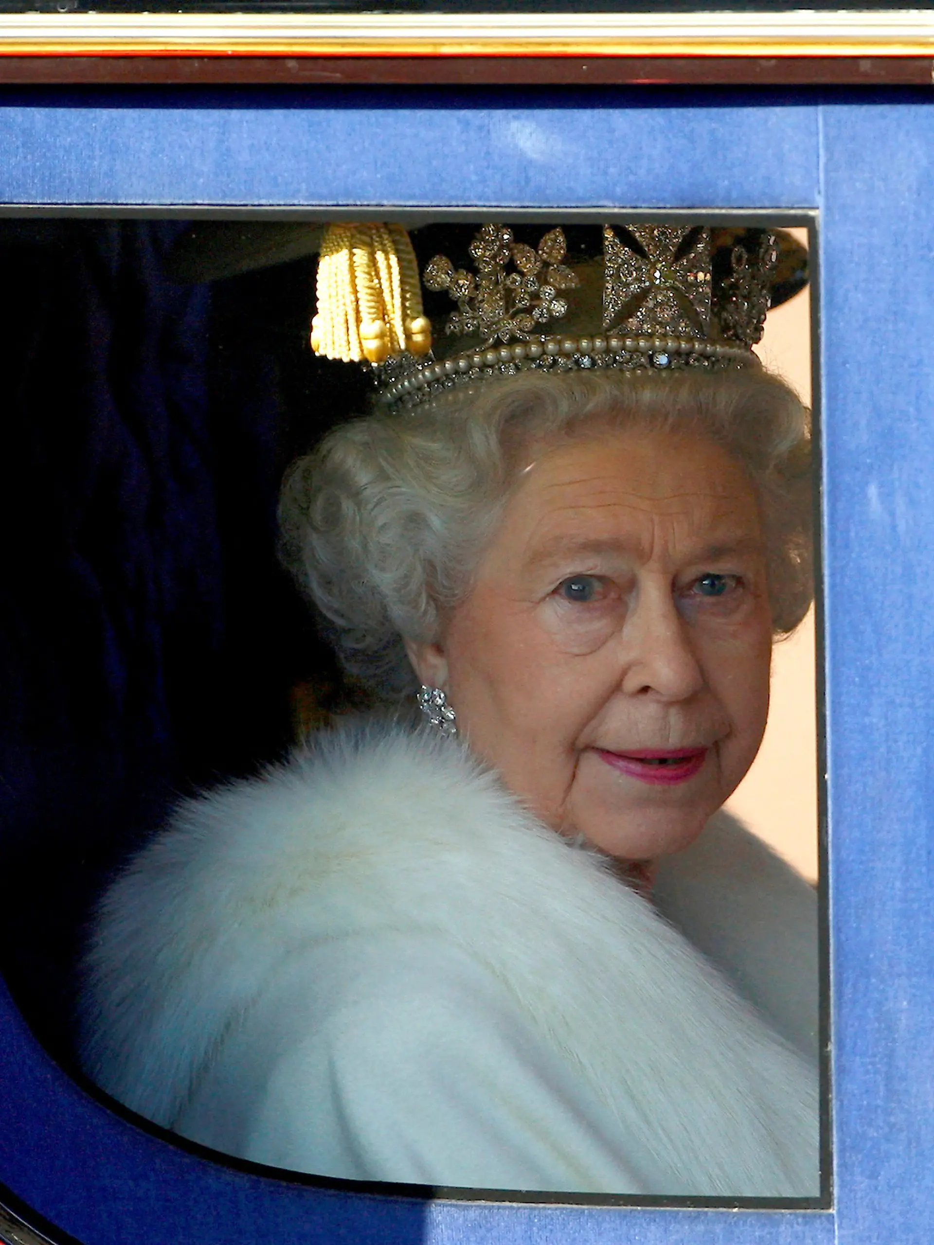 FILE PHOTO: Britain's Queen Elizabeth looks out from her horse drawn carriage as she is driven from Buckingham Palace to the Palace of Westminster for the traditional opening of Parliament in London November 6, 2007.    REUTERS/Dylan Martinez/File Photo