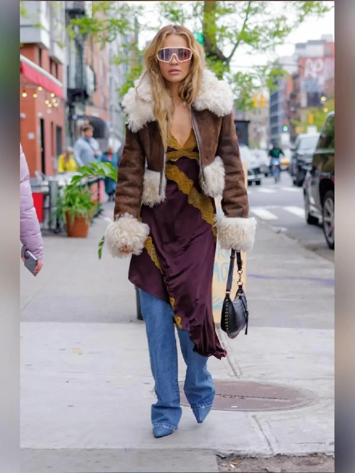 Rita Ora trägt ein Kleid kombiniert mit Bootcut-Jeans